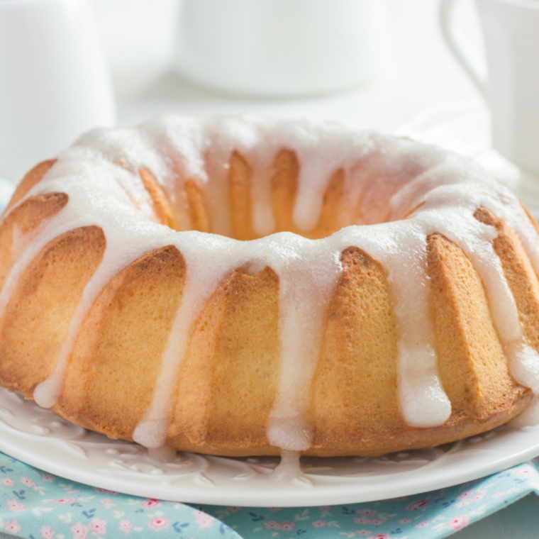Lemon glaze being poured over an air fryer lemon bundt cake