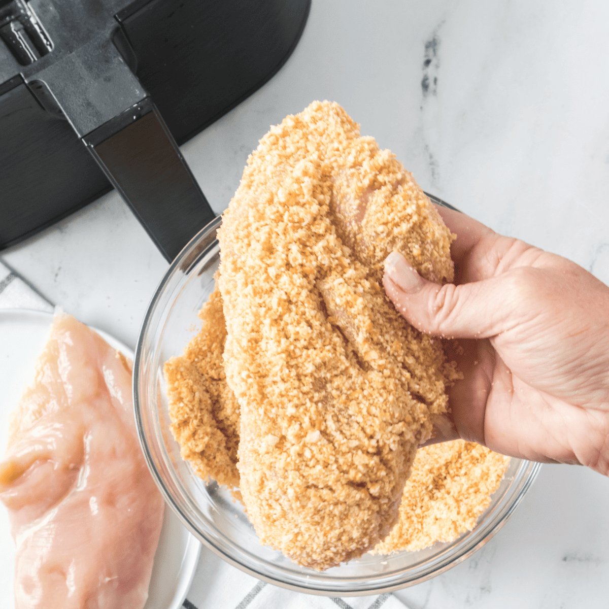 Coat the chicken with crushed Ritz crackers, ensuring an even coverage for a crispy texture