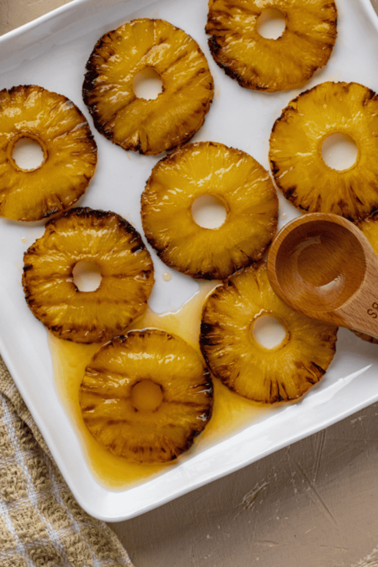 Golden honey glazed pineapple slices cooking in an air fryer basket, ready to serve