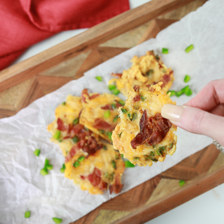 Hand holding a single crispy air fryer cheese crisp up close