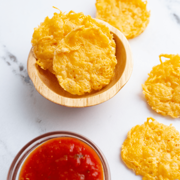 Lacy air fryer cheese crisps lifted off parchment with a thin spatula