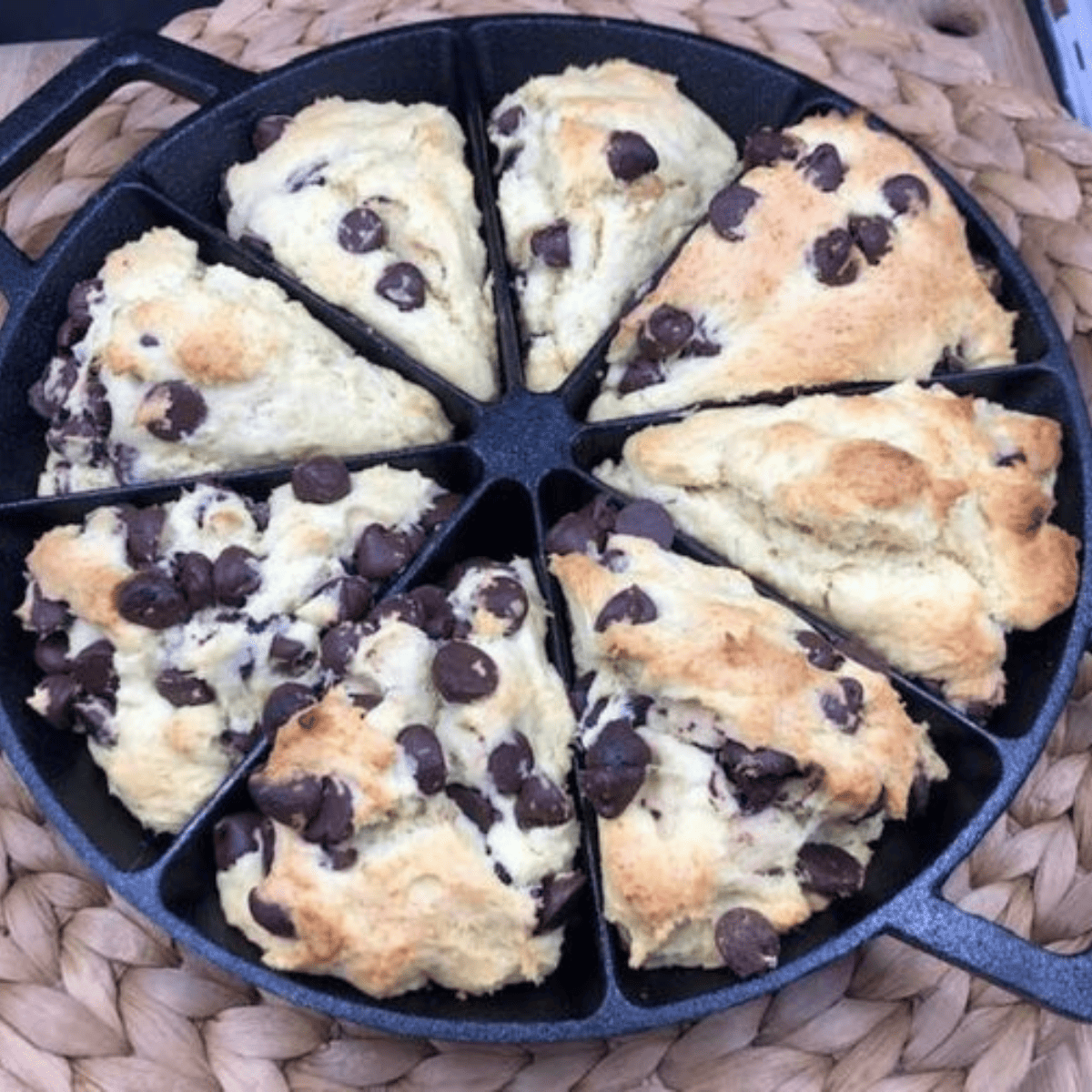 Air fryer chocolate chip scones with golden edges and melty chocolate chunks, served on a plate.