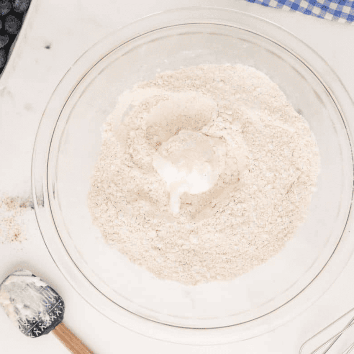 Folding mini chocolate chips into the scone dough with a spatula.