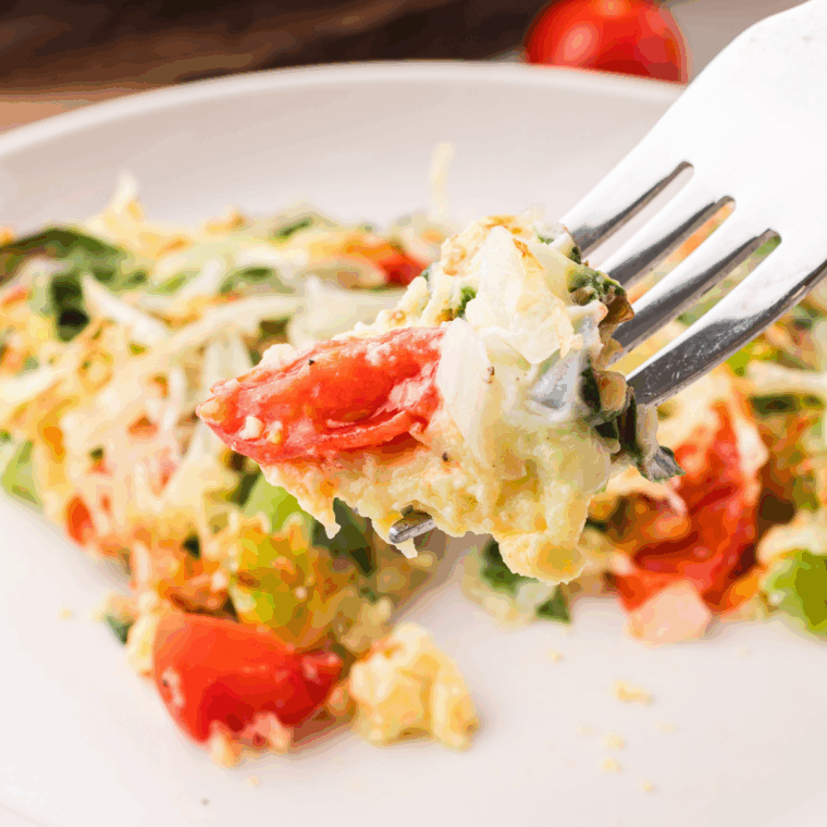 Air fryer First Watch Frittata Rustica with eggs, spinach, cherry tomatoes, bell peppers, and melted cheese, served warm.