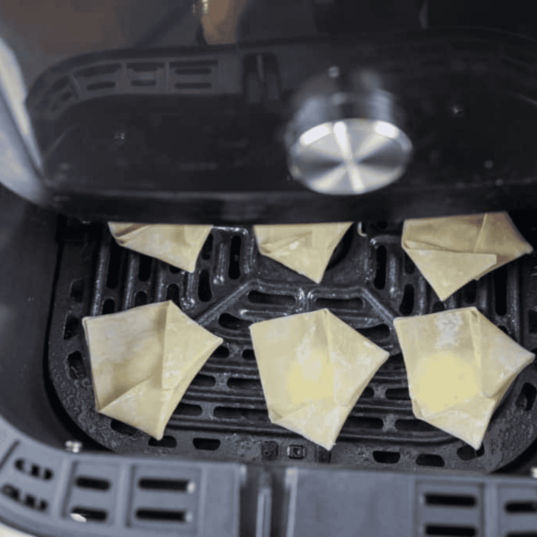 Arrange the cream cheese Rangoon in the air fryer basket or tray without overcrowding, then spray with olive oil to achieve a crispy golden finish.