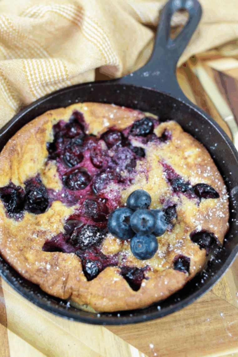 Golden air fryer Dutch baby pancake topped with fresh blueberries