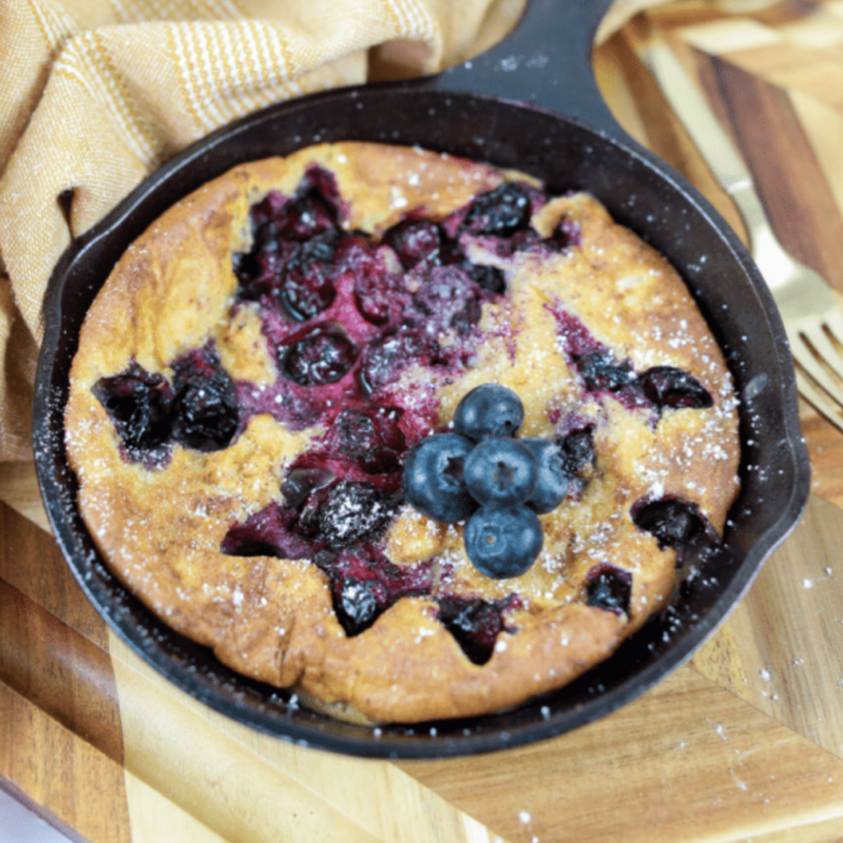 Golden air fryer Dutch baby pancake topped with fresh, bursting blueberries