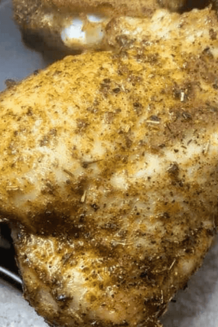 Plate of juicy Air Fryer Caribbean Rubbed Chicken Thighs garnished with fresh lime wedges