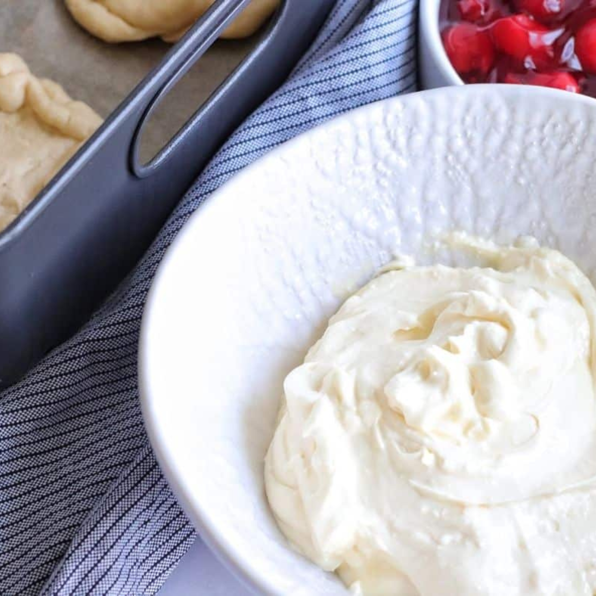 Mixing cream cheese, egg, vanilla, lemon juice, and sugar in a bowl.