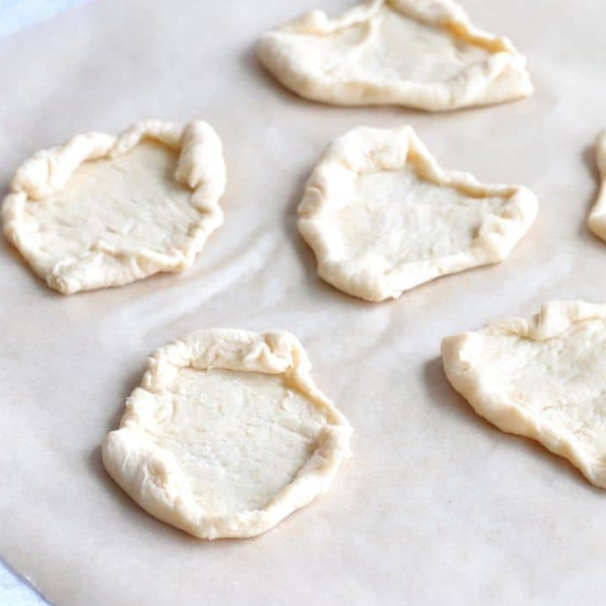 Cutting crescent dough into triangles and shaping edges.