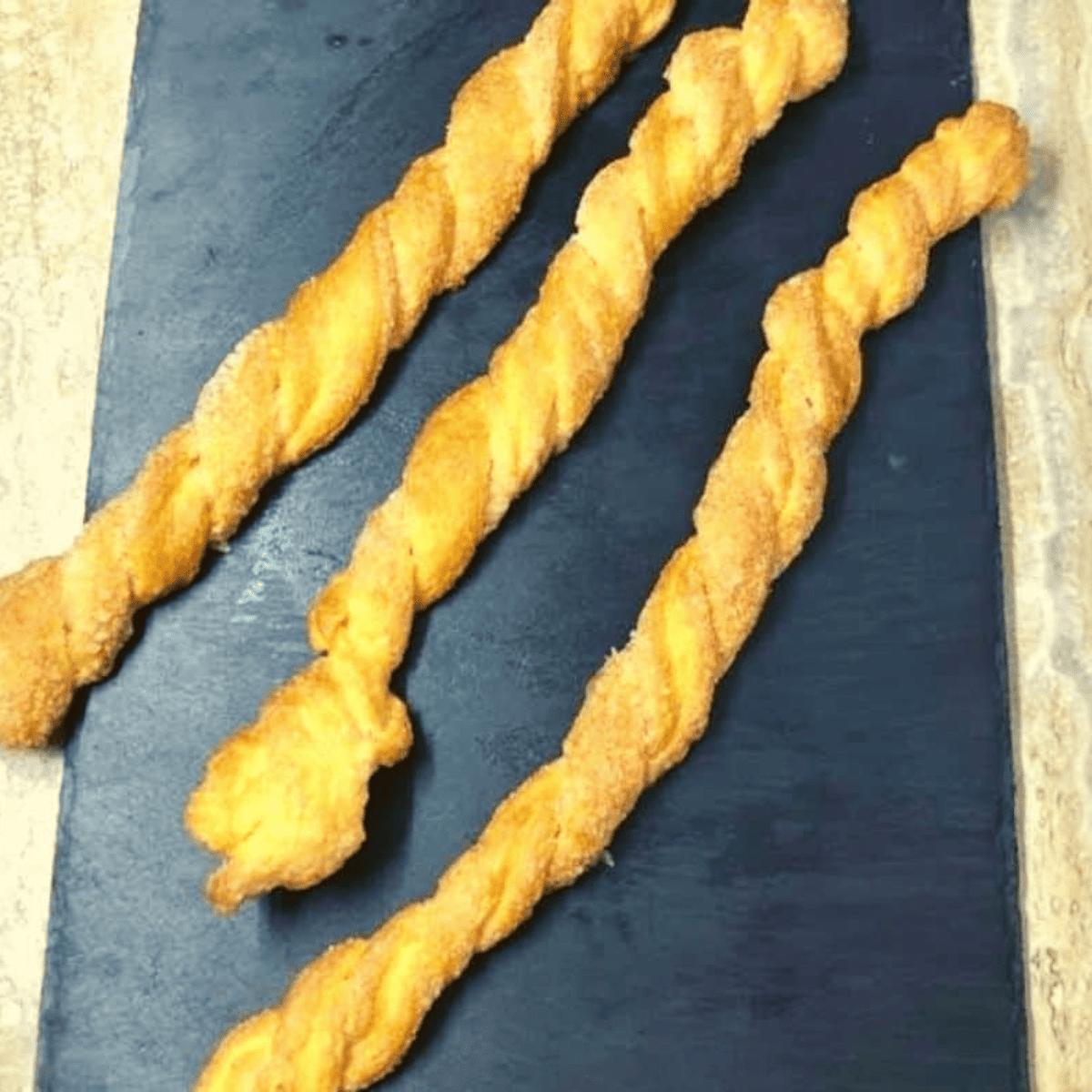 Twist the Strips: Take the long strips and twist it multiple times to create a spiral shape. Place the twisted strips on a baking sheet or plate.
Grease the Air Fryer Basket: Lightly grease the air fryer basket with cooking spray to prevent sticking.
Air Fry the Twists: Arrange the twisted pastry strips in a single layer in the air fryer basket, leaving some space between them. Depending on the size of your air fryer, you may need to cook them in batches.
Air Fry for 6-8 Minutes: Air fry the cinnamon twists at 375°F (190°C) with a cooking time of 6-8 minutes or until golden brown and crispy.
Cool and Serve: Remove the twists from the air fryer and let them cool slightly. Optionally, dust with powdered sugar for an extra touch of sweetness.
Enjoy: Serve your cinnamon roll twist while still warm and crispy. Serve with sweet cream cheese or your favorite dipping sauce.