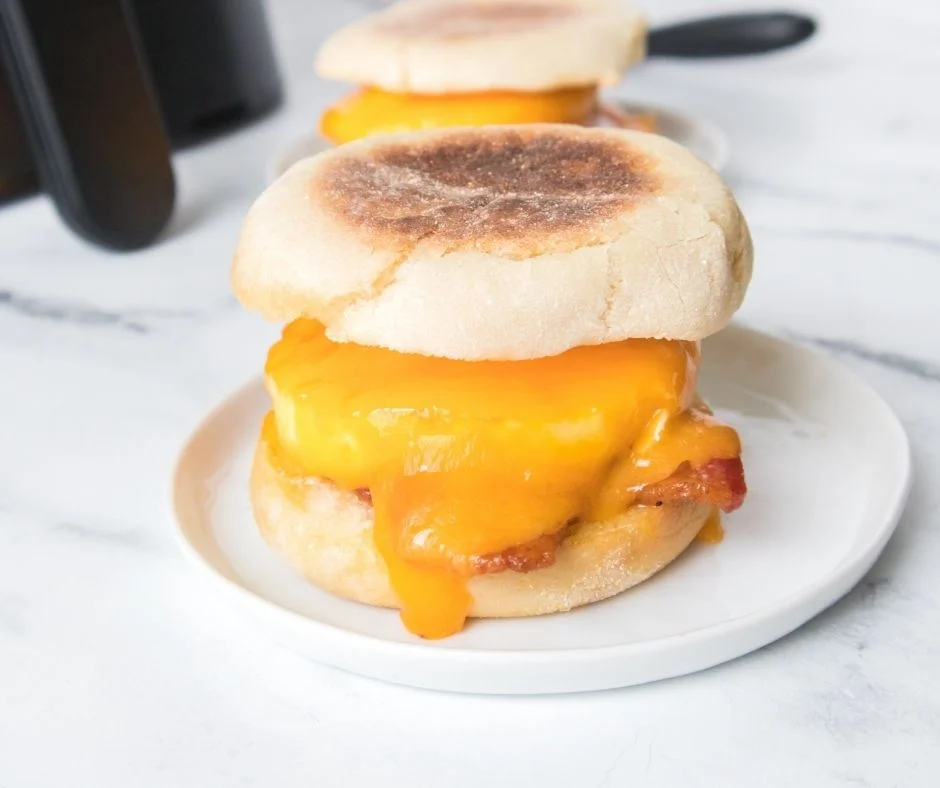 Air Fryer Egg McMuffin with egg, melted cheese, and sausage on a toasted English muffin