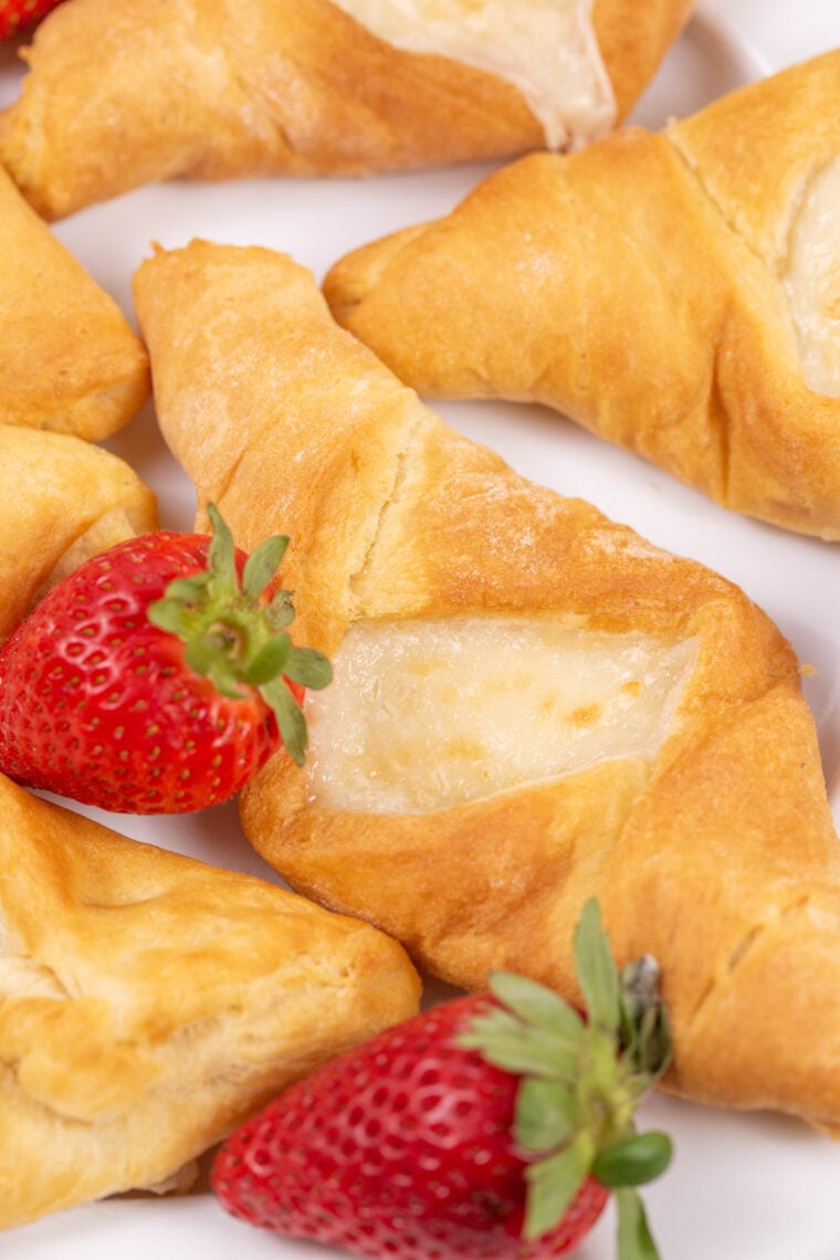 Four golden air fryer cheese danishes arranged on parchment, fresh from the air fryer