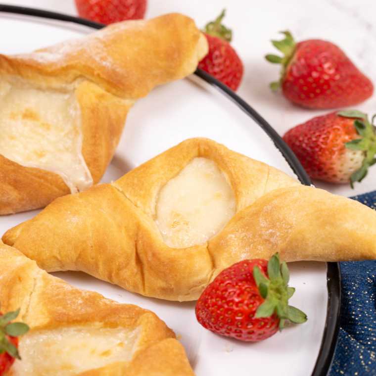 Golden brown air fryer cheese danishes resting on a wire rack after cooking
