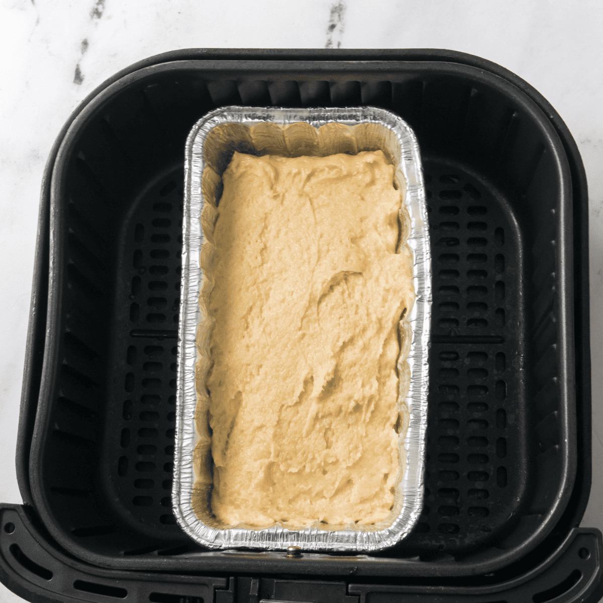 Air fryer lemon loaf baking at 330 degrees until a toothpick comes out clean