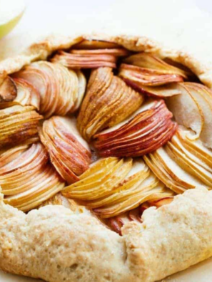 Golden air fryer pear galette with thinly sliced pears fanned inside a rustic folded crust, cooling in a tart pan