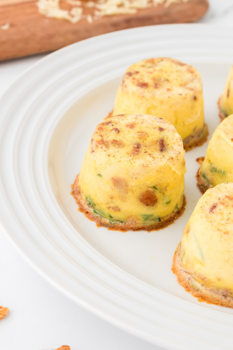 Golden air fryer truffle, mushroom, and brie egg bites on a plate, garnished with fresh chives