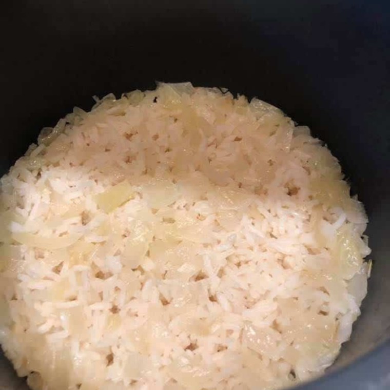 Cooked rice and onions in the pressure cooker basket.