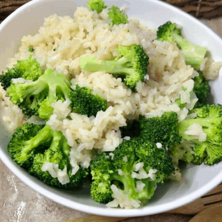 Creamy and cheesy broccoli and rice dish cooked in an Instant Pot, garnished with fresh herbs.