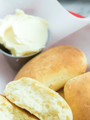 Golden Sister Schubert's dinner rolls in an air fryer basket brushed with melted butter
