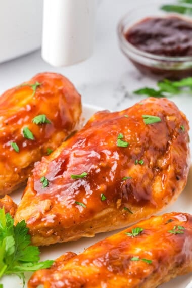 Juicy air fryer BBQ chicken breast with caramelized barbecue sauce on a white plate