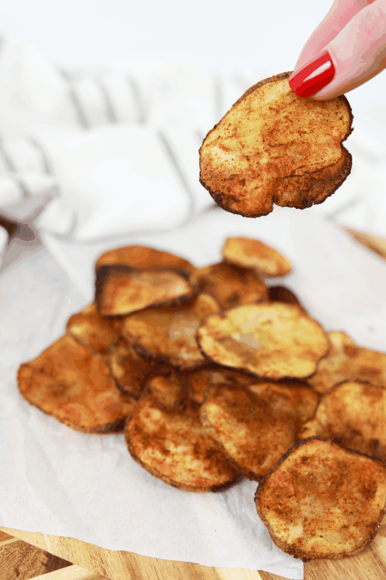 Golden, crispy Air Fryer BBQ potato chips in a bowl, sprinkled with BBQ seasoning