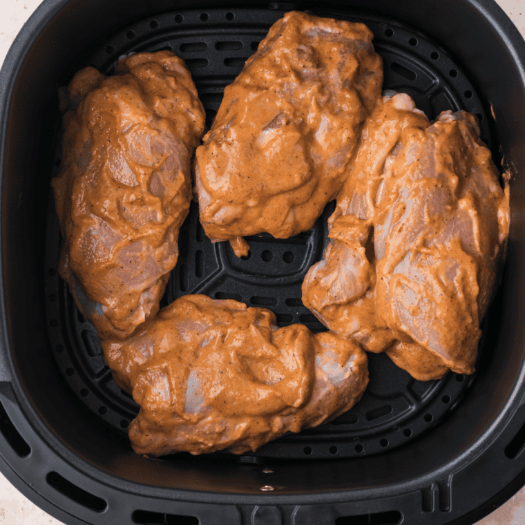 Chicken thighs in balsamic glaze cooking in the air fryer at 350°F