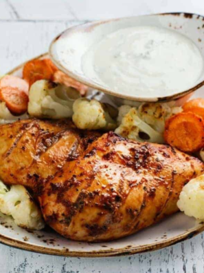 Grilled chicken tenders cooked in the air fryer, golden brown and juicy, served on a white plate with dipping sauce.