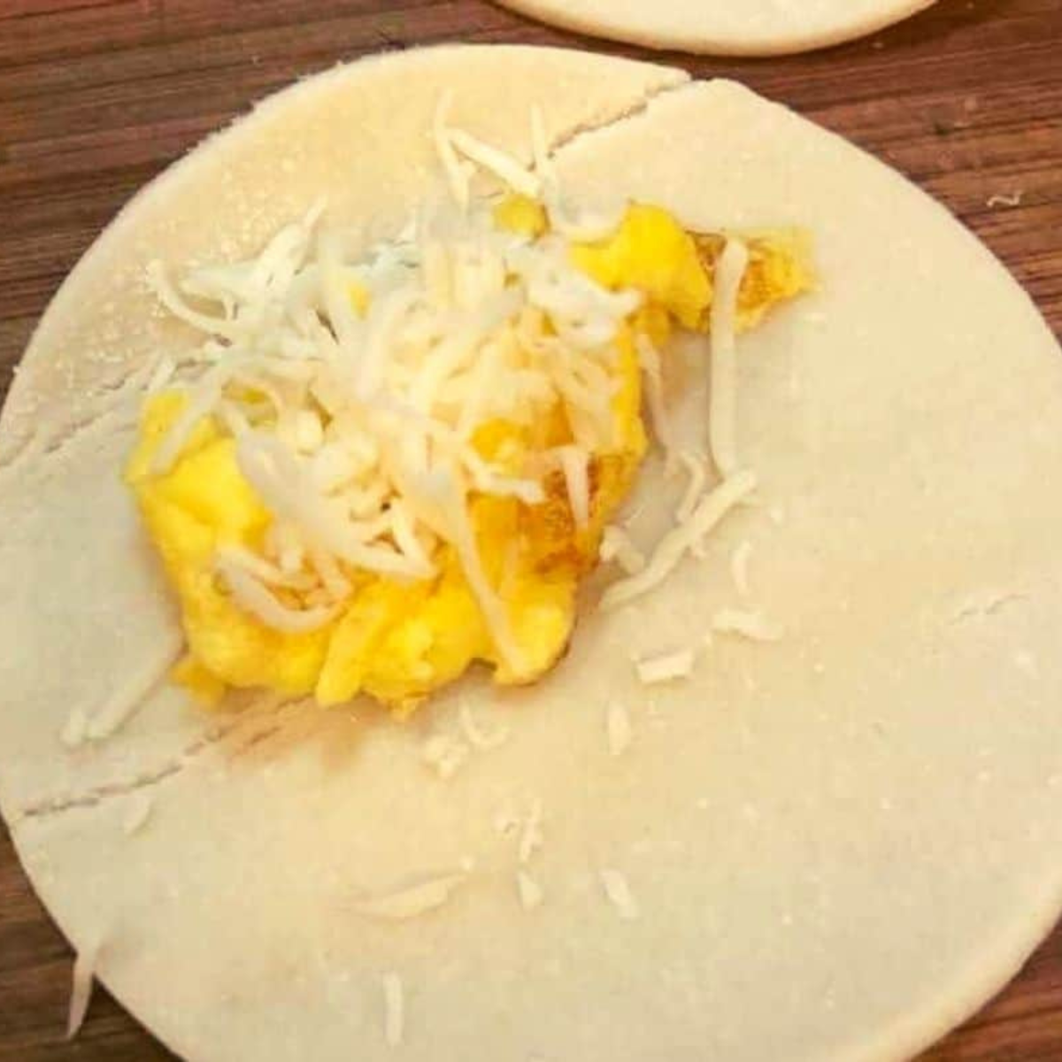 Filling the bagel pockets with scrambled eggs and cheese.