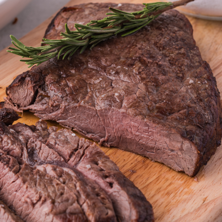 Close-up of air fryer New York strip steak with melted Boursin butter melting over steak