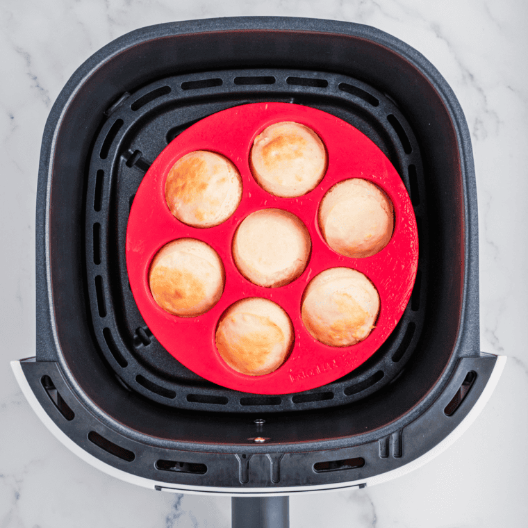 Egg bite mold filled with pancake batter placed in an air fryer basket, ready to cook at 320°F.