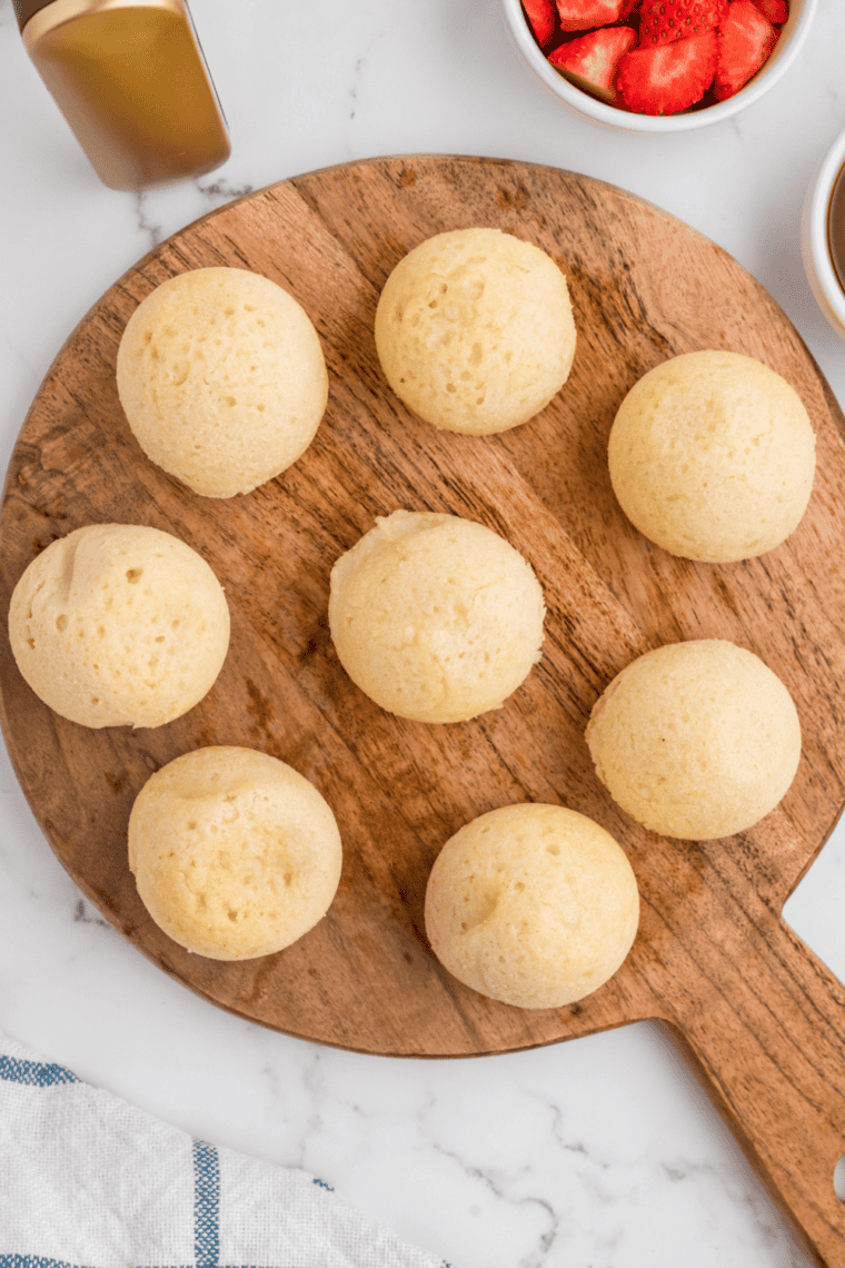 Freshly cooked Air Fryer Pancake Bites arranged on a wooden cutting board, ready to serve.