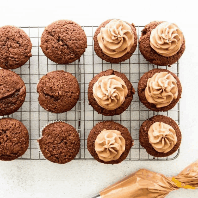 Filling muffin cups two-thirds full with batter, topping with reserved chocolate chips, and baking in the oven until golden and a toothpick comes out clean.