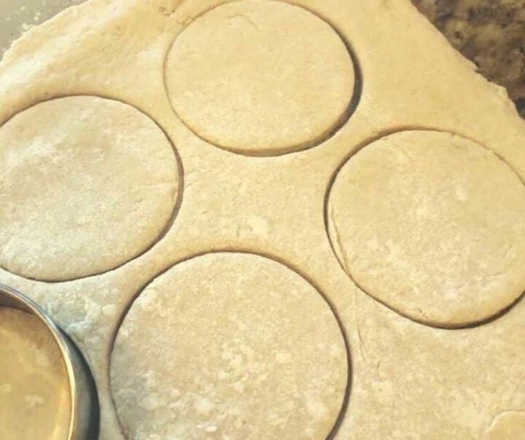 Freshly cut Bisquick biscuit dough pieces on a floured surface, ready for baking.