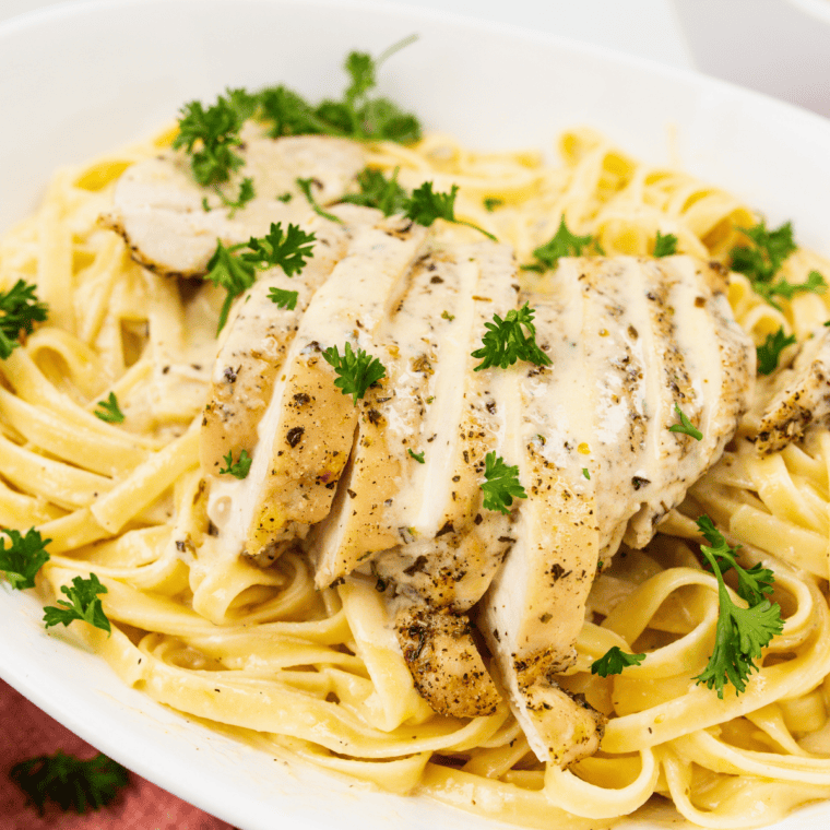 Serving spoon lifting cheesy Parmesan pasta from an Instant Pot insert