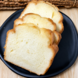 Golden 4 ingredient air fryer pound cake sliced on a black plate.
