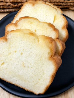 Golden 4 ingredient air fryer pound cake sliced on a black plate.