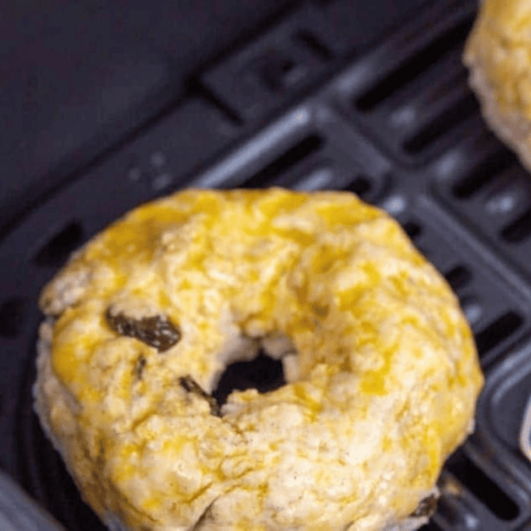 Air Fryer Cinnamon Raisin Bagels cooking in the air fryer basket"