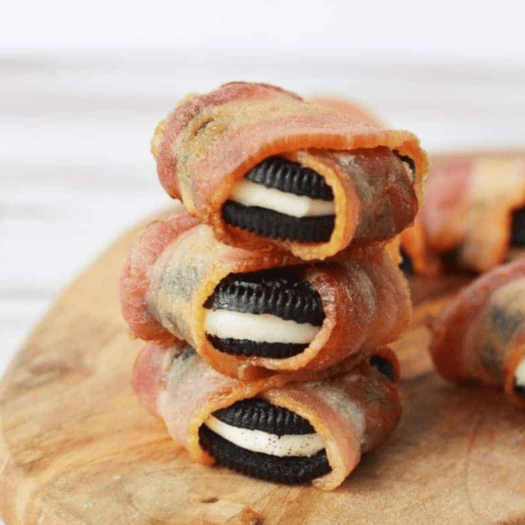 Air Fryer Bacon Wrapped Oreos served on a rustic wooden table, garnished with fresh mint leaves.