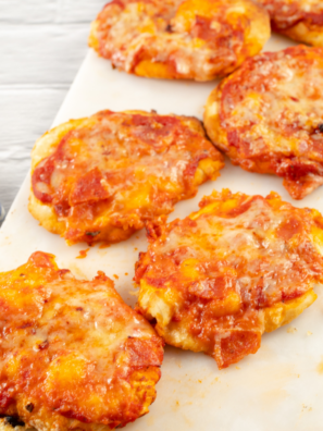 Air fryer biscuit pizza with golden crisp crusts and melted mozzarella served on a white plate
