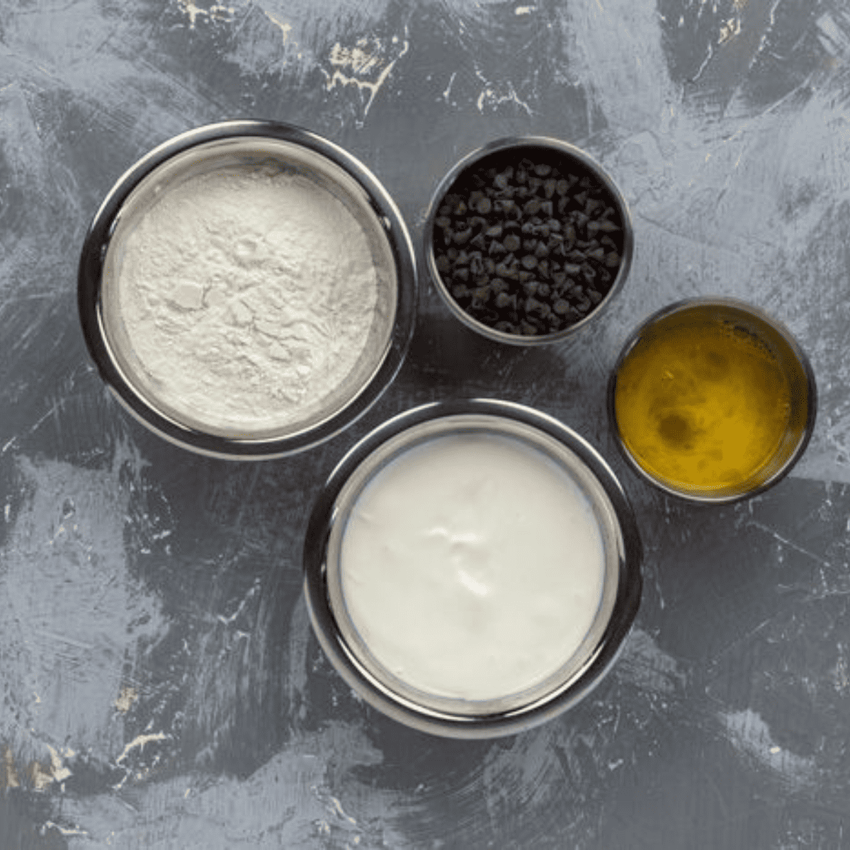 Ingredients laid out for Air Fryer chocolate chip bagels including flour, sugar, chocolate chips, and other baking essentials.