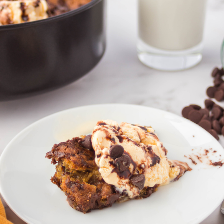Air fryer chocolate chip cookie pizza sliced into wedges and topped with vanilla ice cream