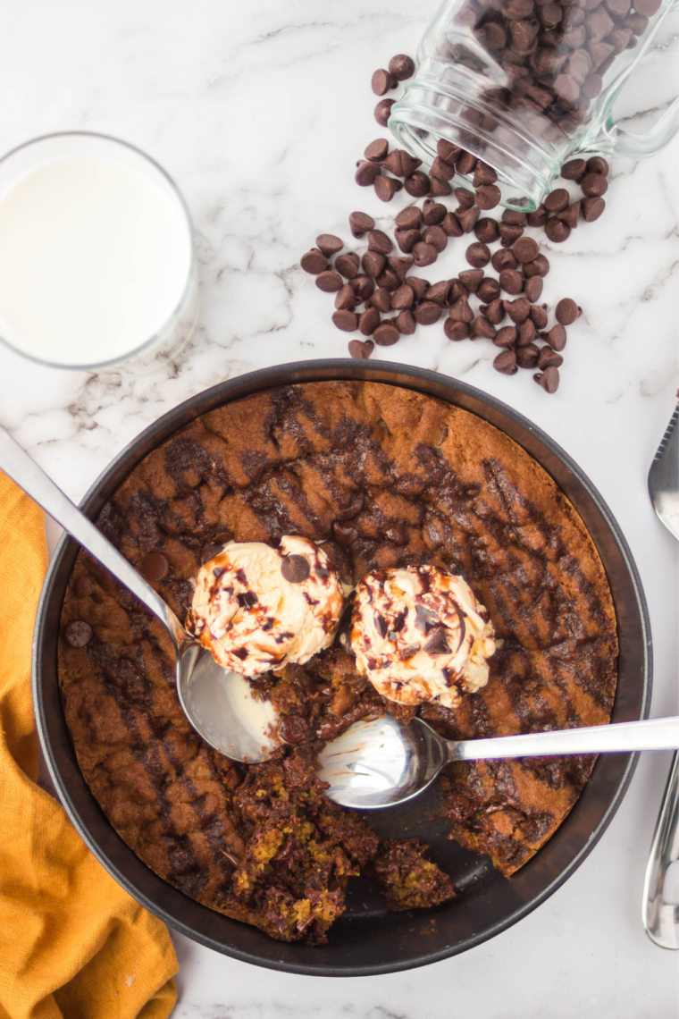 Air fryer chocolate chip cookie pizza sliced into wedges on a wooden board