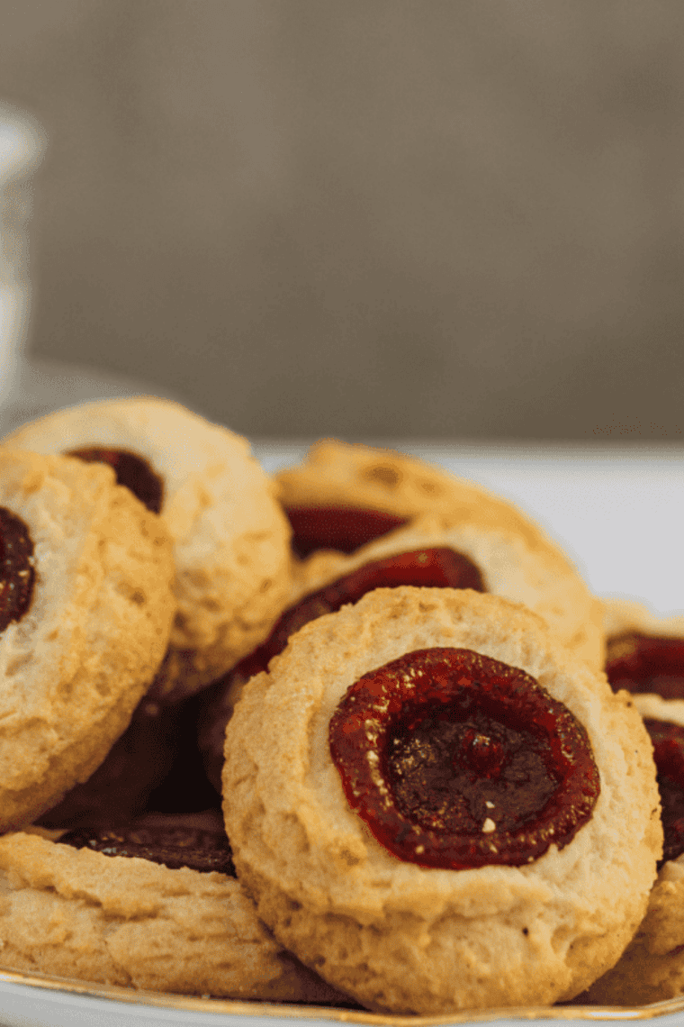 Golden thumbprint cookies fresh from the air fryer, soft and filled with fruity jam centers.