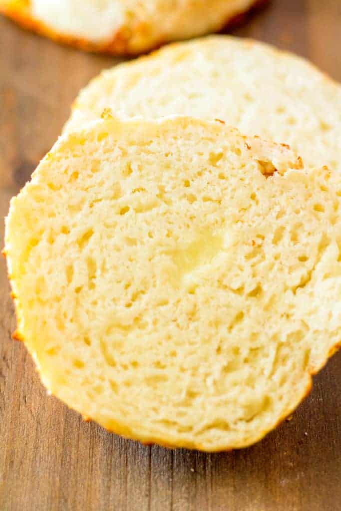 Cut open asiago bagel showing a soft, fluffy interior with a golden, crispy crust.