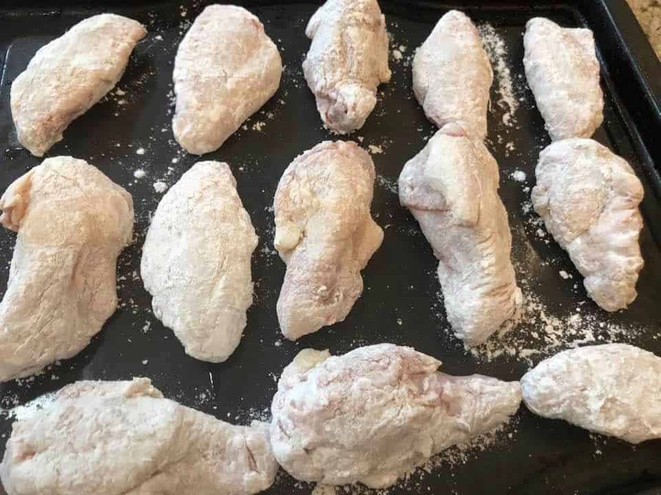 Prepping chicken wings for air frying with seasoning and red pepper jelly marinade.
