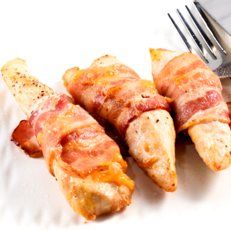 Close-up of bacon wrapped chicken cooked in the air fryer with melted cheese inside and crispy edges