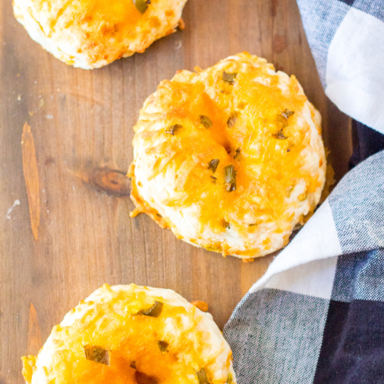 Plate of warm jalapeno and cheddar bagels, with visible chunks of jalapenos and melted cheddar