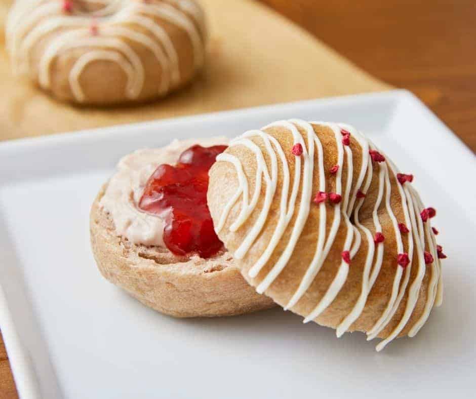 Golden-brown air fryer strawberry bagels topped with a layer of sweet strawberry spread.