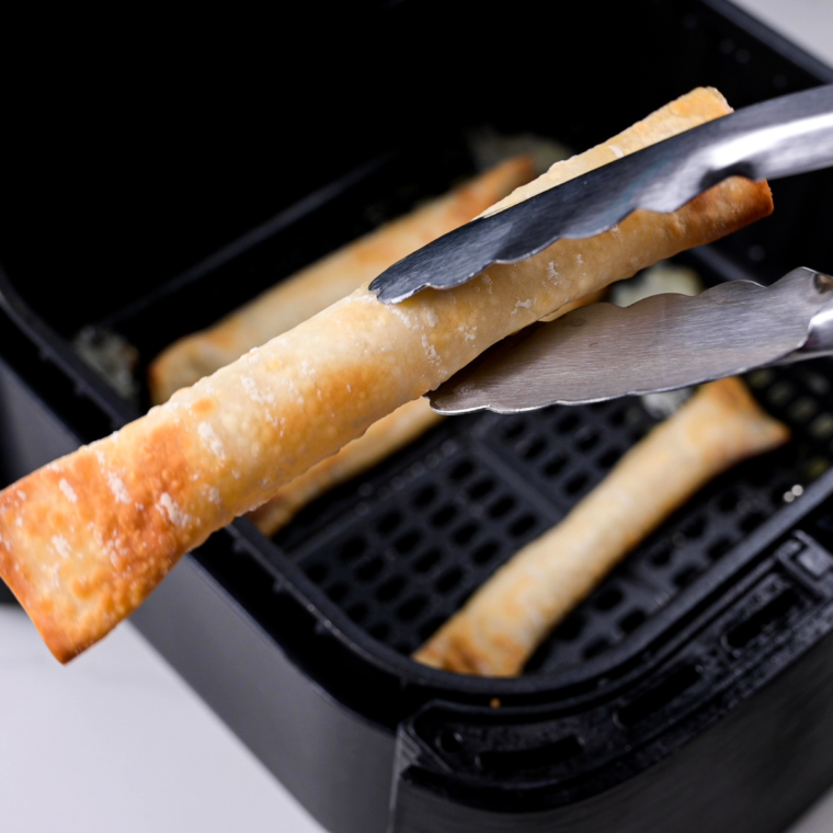 Air Fryer Wonton Mozzarella Sticks with crispy golden wrappers, gooey melted mozzarella, and marinara dipping sauce on a plate.